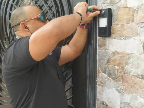 Técnico instalando equipo en pared de piedra
