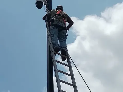 Técnico instalando una cámara en lo alto de un poste